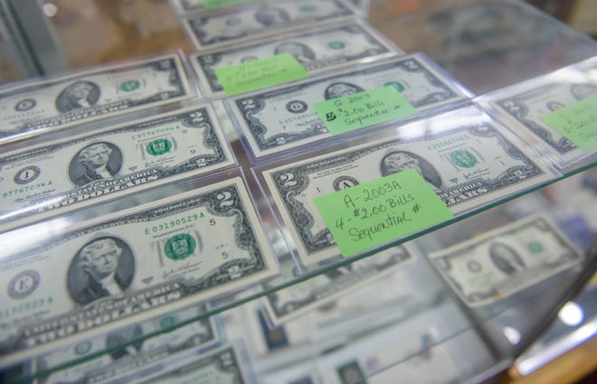 Sets of two-dollar bills fill part of a display case at the A-Z Jewelry & Swap Co. on Adam's Street in downtown Peoria.
