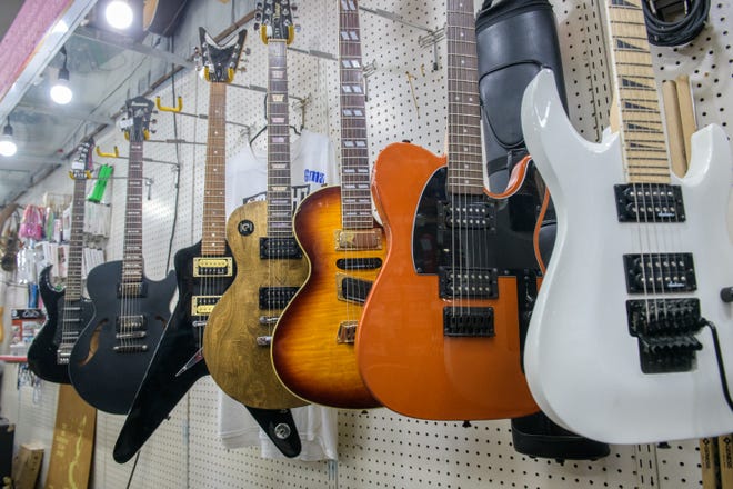 A line of guitars hang on a display wall at A-Z Jewelry $ Swap Co. in downtown Peoria.