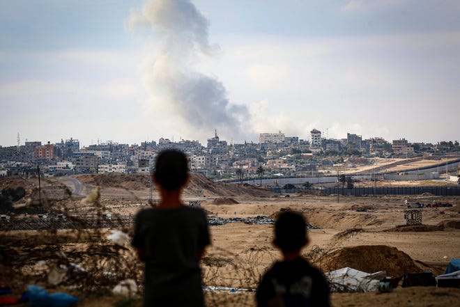May 13, 2024: Boys watch smoke billowing during Israeli strikes east of Rafah in the southern Gaza Strip amid the ongoing conflict between Israel and the Palestinian militant group Hamas.